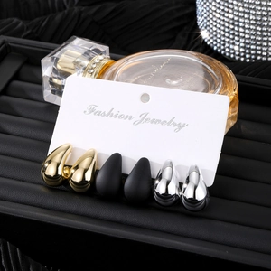 Set de tres pares de pendientes de gota en acabados dorado, plateado y negro mate