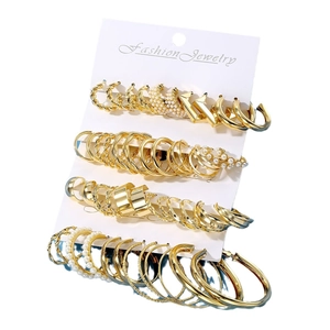 Set di orecchini dorati con cerchi geometrici e perle sintetiche su cartoncino