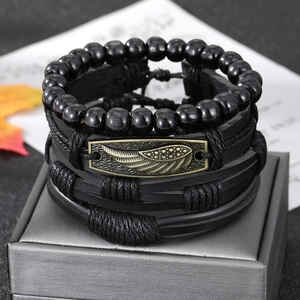 Dettaglio del bracciale multistrato in pelle nera con piuma di bronzo su espositore