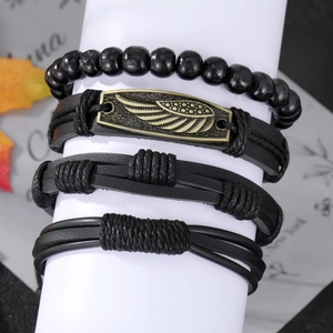 Dettaglio del set di quattro bracciali da uomo in pelle con piuma vintage e perle