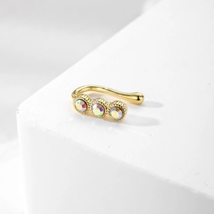 U-shaped non-piercing gold nose cuff featuring three iridescent rhinestones on white stone