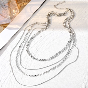 Layered silver chain necklace featuring snake, figaro and box styles for a chic metal look