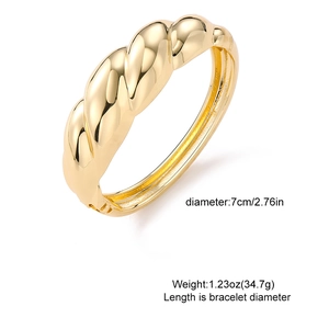 Golden chunky twisted metal cuff bracelet with high-polish mirror texture and spiral design