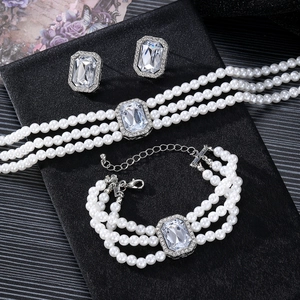 Dreiteiliges Schmuckset mit mehrlagiger Perlenkette, Armband und Kristallsteckern