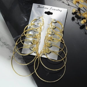 Detail view of 6 pairs of gold-plated textured hoop earrings on a silver card display