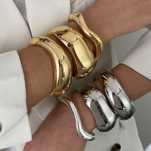 Modern minimalist fluid geometric bangle in gold and silver finish with mirror polishing