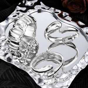 Irregular liquid metal geometric bracelets and rings set on silver textured tray