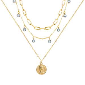 Close-up of triple-layered golden necklace with zircon charms and coin pendant