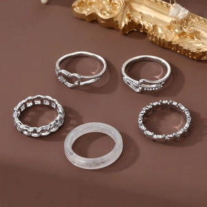 Five-piece silver jewelry set featuring butterfly necklaces and heart rings on dark background