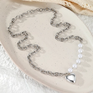 Collar de cadena plateada y perlas con colgante de corazón en bandeja cerámica