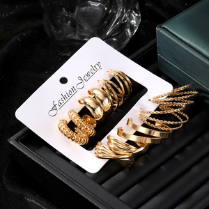 Set aus goldenen Legierungsohrringen mit Zirkonia und Perlen auf einer Displaykarte