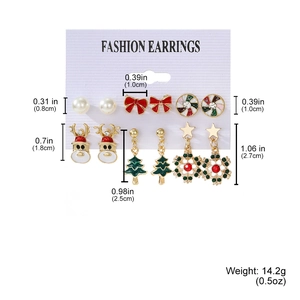 Detailed view of Christmas earring set with reindeer, tree and snowflake charms on a white card