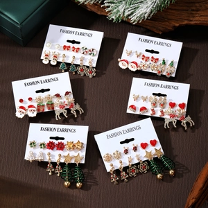 Christmas earring set with Santa, reindeer and tree charms on dark wood background
