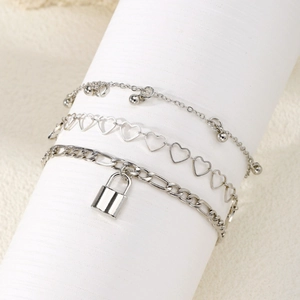 Three-piece silver chain anklet set featuring heart charms, a lock pendant, and beads