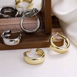 Polished chunky hoop earrings set in gold and silver finish with minimalist design