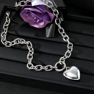 Silver chunky chain link necklace with a 3D heart pendant on black leather display