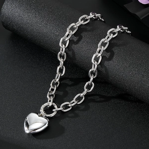 Polished silver layered heart pendant necklace with thick chain links on black display