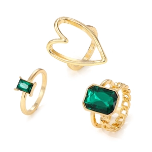 Golden stackable ring set with heart shape and emerald green gemstone accents