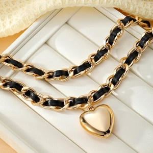 Elegante collar de varias capas en oro con trenza de cuero negro y dije de corazón