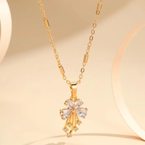 Elegant gold bow necklace with flower pendant and tassels featuring zircon stones