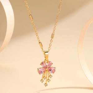 Detailed macro view of the gold flower pendant with pink zircons and tassels on a chain