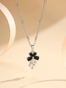 Detail of silver clover pendant necklace with black pear-shaped stones and tassel droplets