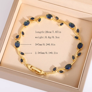 Dettaglio di un braccialetto a foglia d'oro con pietre blu e cristalli in una scatola