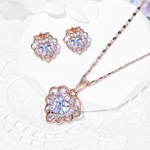 Elegant rose gold jewelry set with heart-shaped necklace and matching stud earrings