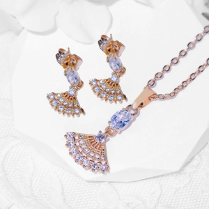 Rose gold jewelry set with fan-shaped zircon necklace and stud earrings on white display