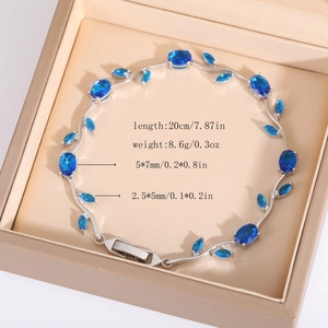 Vista macro dettagliata di un bracciale a vite in argento con zaffiri blu su raso