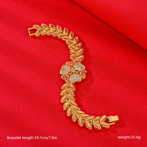 Detailed view of clover bracelet showing 19.7cm length and 25.4g weight on red fabric