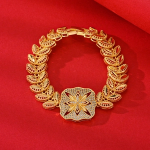 Elegant gold zircon bracelet with floral leaf design on vibrant red background