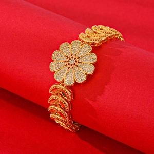 Exquisite gold plated floral bracelet with white zircon petals on a red textured display