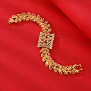 Luxurious gold zircon bracelet with wheat leaf links on a textured red background