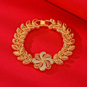 Elegant gold-plated flower bracelet with leaf links and sparkling zircon stones on red background
