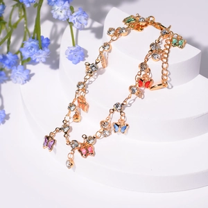 Détail du bracelet plaqué or avec breloques papillons colorées et cristaux de zircon
