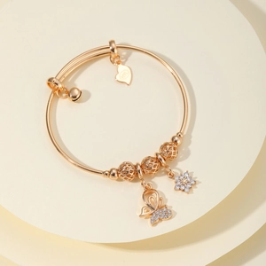 Pulsera dorada con dijes de mariposa y copo de nieve con incrustaciones de circón
