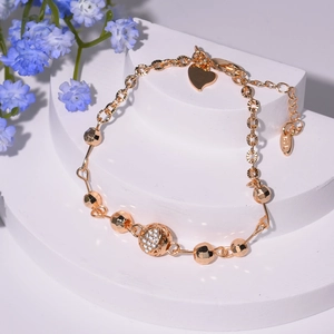 Détail d'un bracelet à pampilles plaqué or 18K avec cœur en zircone et fermoir mousqueton