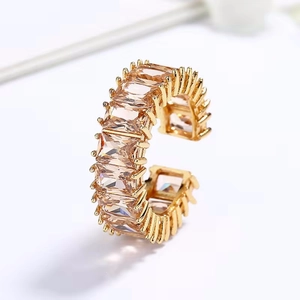 Detail van een vergulde ring met baguette-geslepen champagne zirkonen en open design