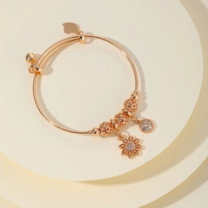 Brazalete de flores en oro rosa con colgante de margarita y circonitas brillantes