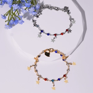 Détail de bracelets étoiles or et argent avec zircons colorés sur présentoir blanc