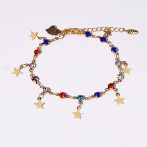 Vue détaillée d'un bracelet doré avec zircons colorés et breloques en étoile
