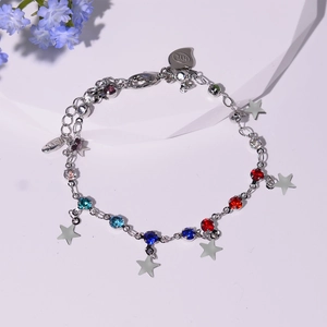 Détail du bracelet en chaîne argentée avec zircons colorés et breloques étoiles