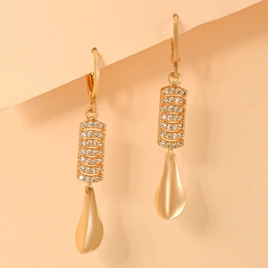 Close-up of gold plated drop earrings with micro-paved zircons and matte metal finish