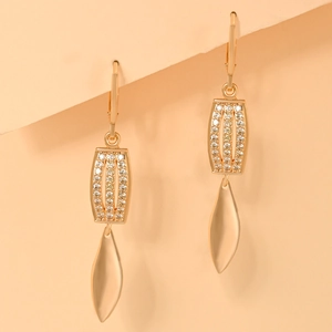 Close-up of gold plated drop earrings featuring leaf charms and sparkling zircon crystals