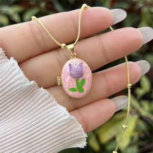 Détail d'un médaillon plaqué or 18K avec émail rose et motif de tulipe violette