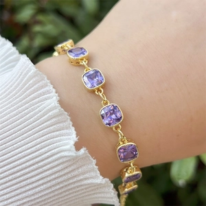 18k gold plated copper bracelet featuring purple cubic zirconia square gems on a wrist