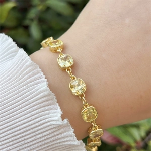 Detail of 18k gold plated bracelet with square yellow zirconia gems on a wrist