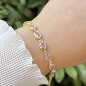 Detail of 18k gold plated bracelet with pink oval zircon stones and beaded edges