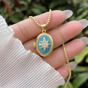Detailopname van de gouden locket met hemelsblauw emaille en een sterrenhanger